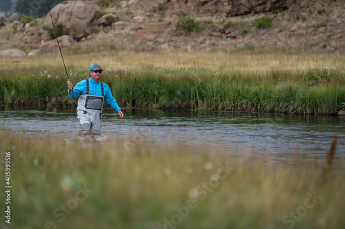 Male fly fishing in a stream in Colorado, USA during Fall