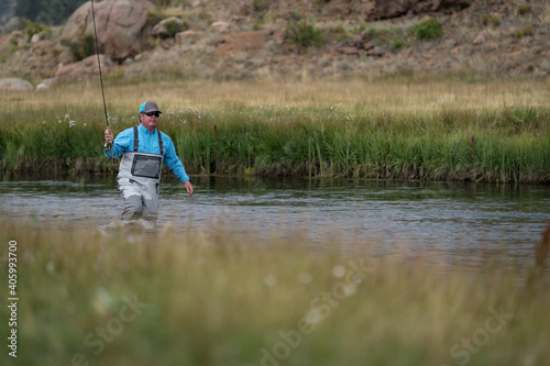 Male fly fishing in a stream in Colorado, USA during Fall