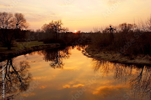sunset. sunset over the river. atmospheric golden sunset over the river with reflection in water in the spring evening