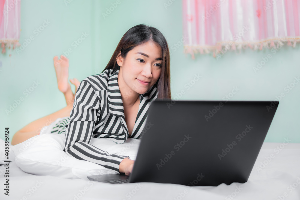 Young asian women use laptop computers at home in the bedroom. work from home concept.. Young asian women use laptop computers at home in the bedroom. work from home concept..