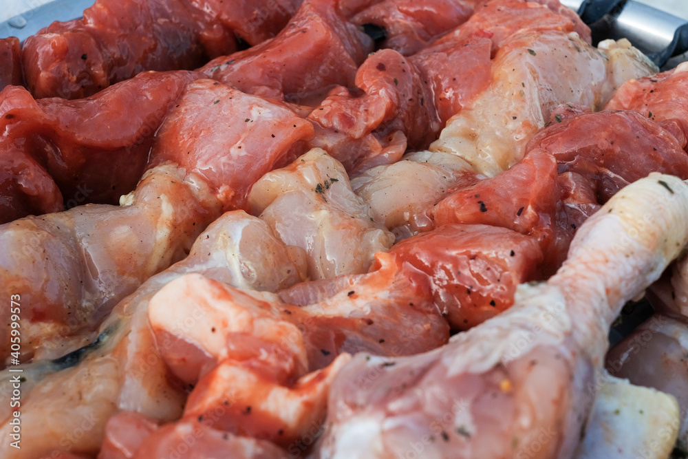 Raw pork skewers and chicken thighs cut into pieces and on skewers closeup Raw pork skewers and chicken thighs cut into pieces and on skewers closeup