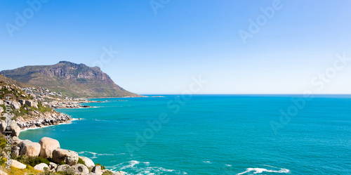 Rocky shore and a calm beautiful seascape view in Cape Town, South Africa under a clear sky
