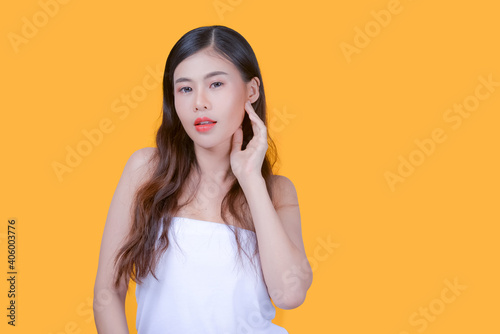 Beauty and healthcare. Portrait of young and beautiful asian woman on yellow background