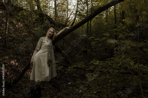 Portrait of a beautiful mysterious woman with blond hair in the forest. like a fairytale. Warm tone 