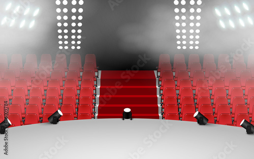 white stage with spotlight and red seats in the hall