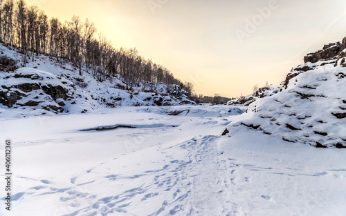 Winter landscape with frozen river, snow, rocks and trees © Александр Коликов