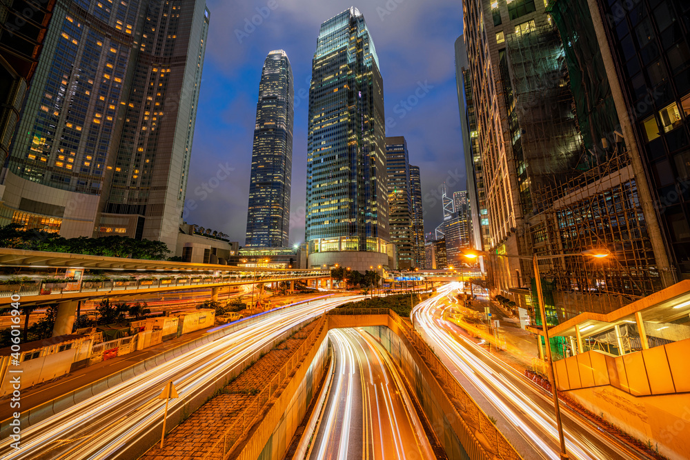 Long exposure of Hong Kong Cityscape skyscaper which have light traffic transportation from car or bus on Central Business District around IFC building, transport and energy industrial concept