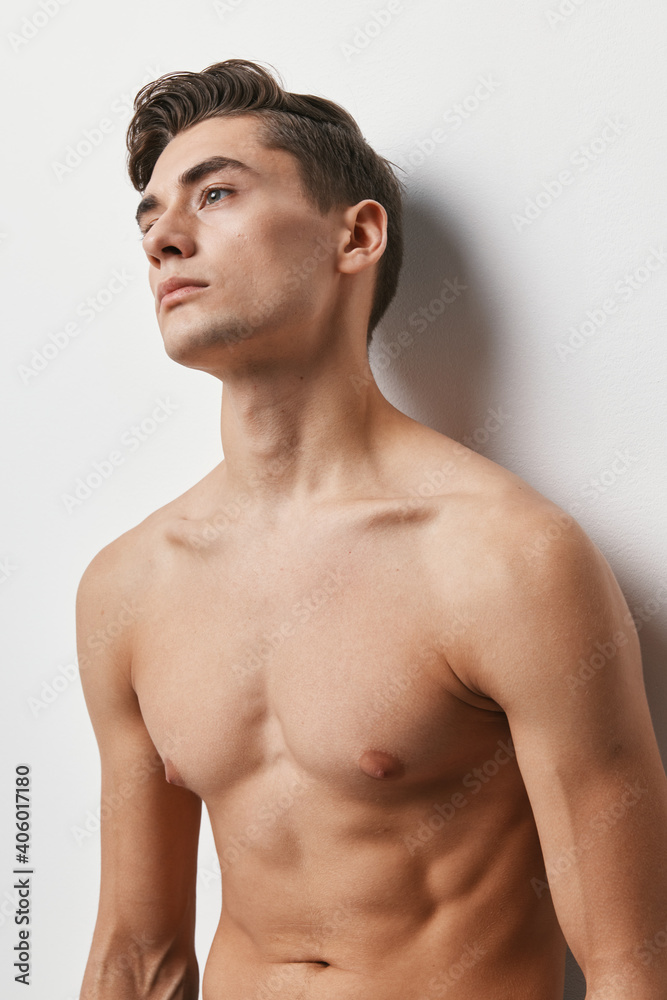 Cropped view of a sexy guy with a naked torso on a light background Cropped view of a sexy guy with a naked torso on a light background