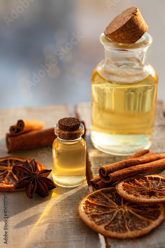 Concept of natural essential oils  orange  cinnamon sticks  anise. Home spa treatment. Aromatherapy  holiday spirit. Winter home fragrances blend. Bright light  close up  macro. Copy space for text
