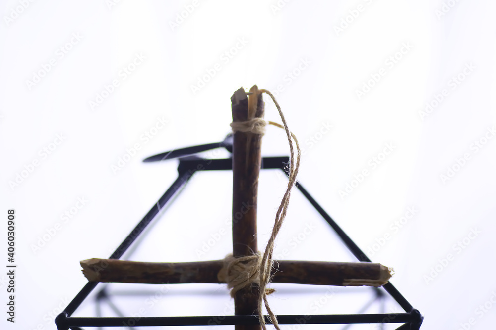 Obraz premium Religious concept. Handmade wooden cross on a white background. Wine glass lamp with candles.