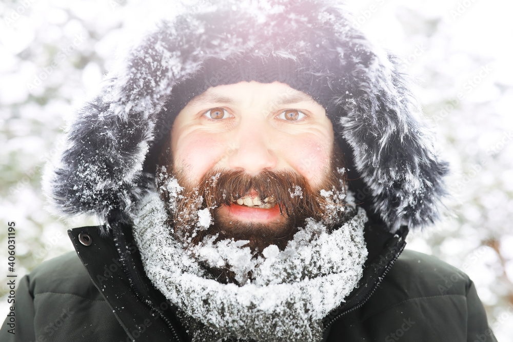 Outdoor portrait of handsome man in coat and scurf. Bearded man in the winter woods. Outdoor portrait of handsome man in coat and scurf. Bearded man in the winter woods.