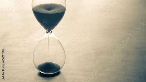 Hourglass on a light background. Time is money. Business solutions in time. © photosaint