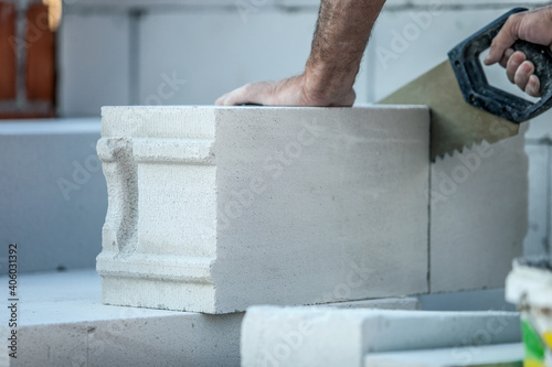 Tablou pe pânză Man builder sawing a gas-silicate brick