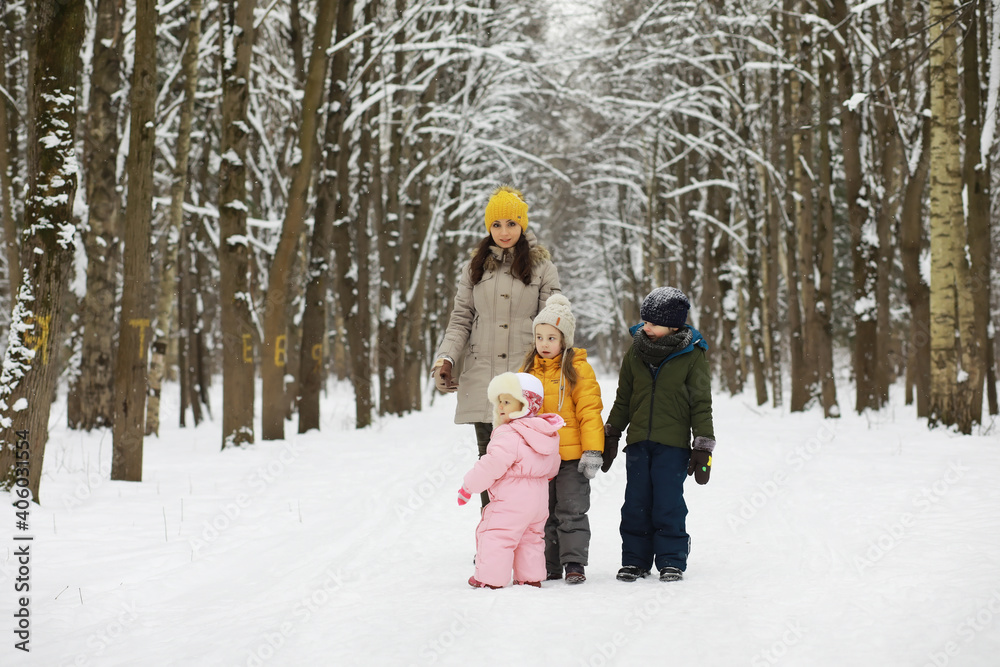 Happy family playing and laughing in winter outdoors in the snow. City park winter day.