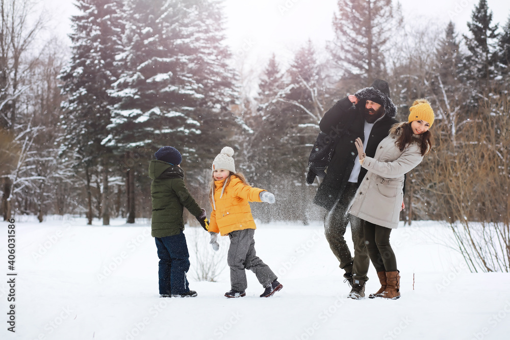 Happy family playing and laughing in winter outdoors in the snow. City park winter day.