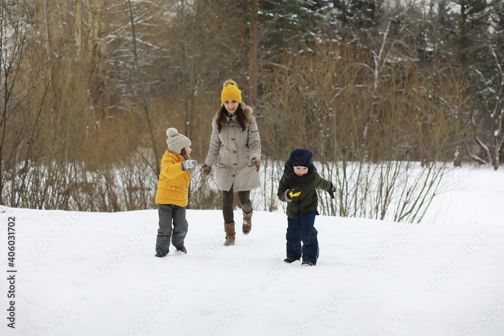 Happy family playing and laughing in winter outdoors in the snow. City park winter day.