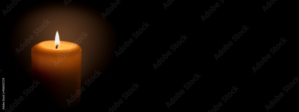 White candle on a black background. The candle flame illuminates the space around it. Banner with space for text. White candle on a black background. The candle flame illuminates the space around it. Banner with space for text.