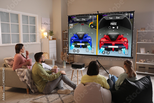 Tablou pe pânză Friends playing video games on big screen at home