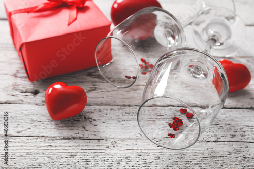 Glasses, hearts and gift for Valentine's Day on wooden background