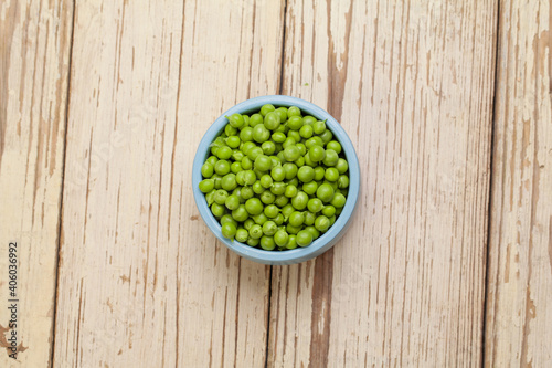 Green peas on white vintage wooden background, organic food concept © artmim