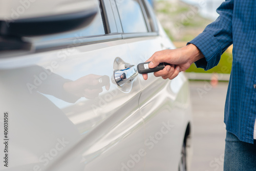 Man holding key opening car door