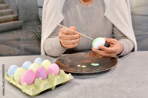 Female hands painting an egg with a brush