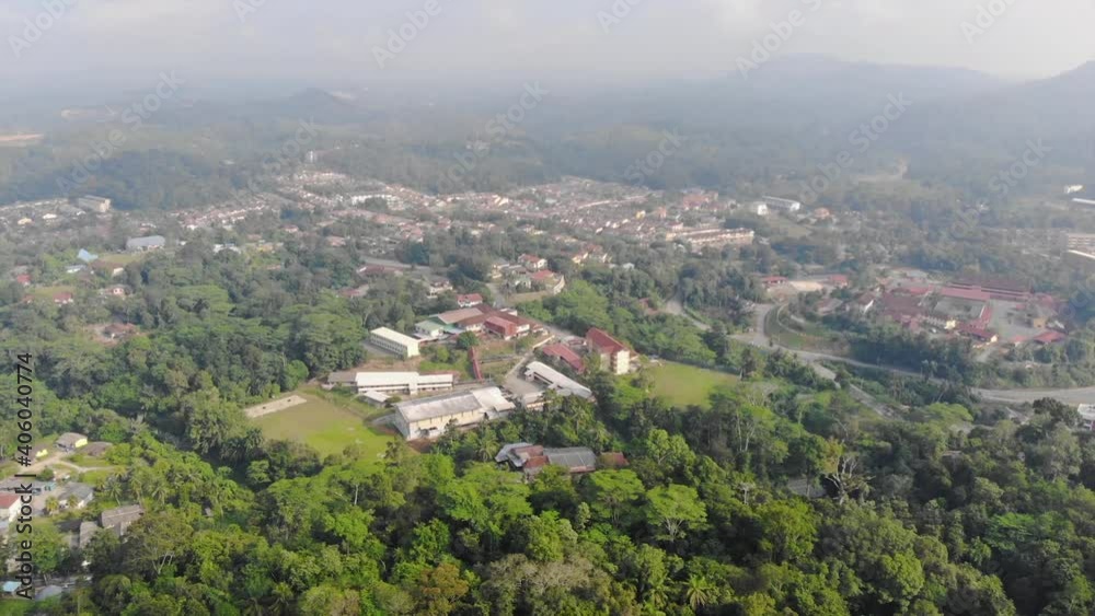 Small Buildings Surrounded By Tropical Forest With Mountains In The Background - Dolly Backwards Small Buildings Surrounded By Tropical Forest With Mountains In The Background - Dolly Backwards