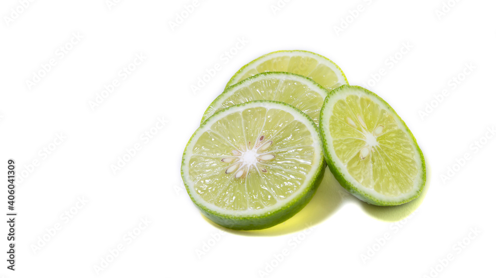 Fresh green Thai lemons, whole and sliced with their leaves, placed on a isolated white background. With copy space. Fresh green Thai lemons, whole and sliced with their leaves, placed on a isolated white background. With copy space.