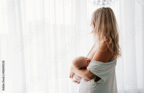 mom feeds baby standing at the window. breast-feeding. Free Download mom feeds baby standing at the window. breast-feeding. - GFXLoad