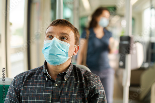 Portrait of male passenger in personal protective equipment traveling in public transport