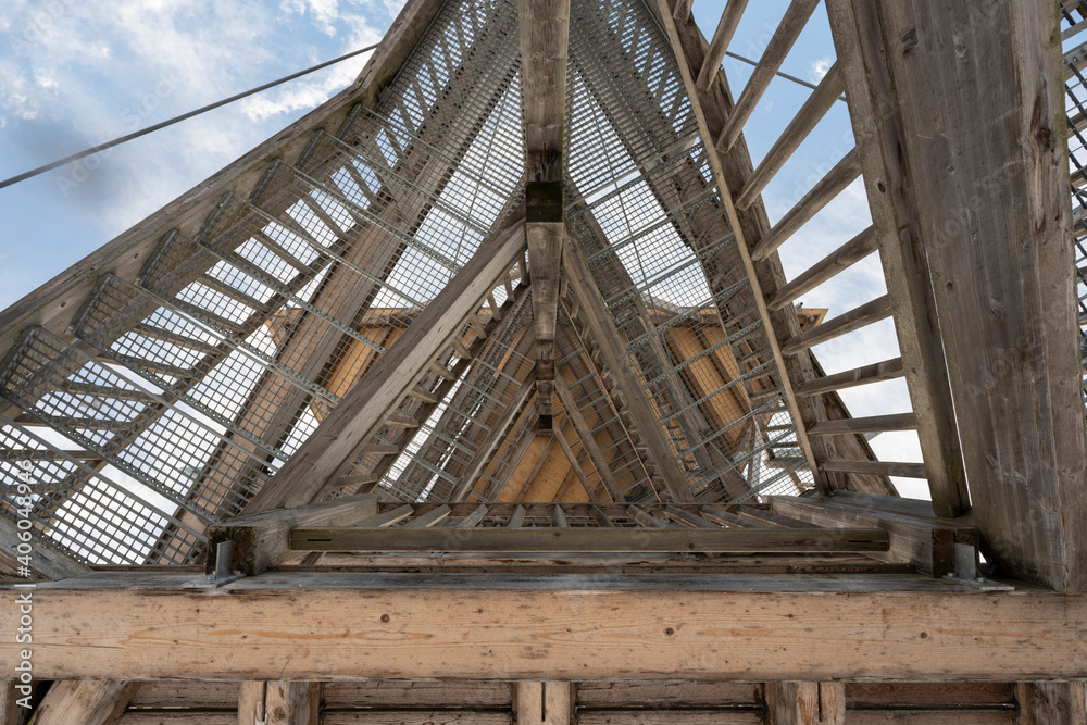 View from the bottom up into a wooden tower construction with stairs