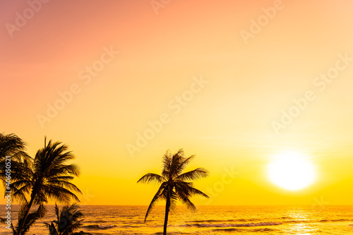 Beautiful tropical beach sea ocean at sunrise or sunset with palm tree © siraphol