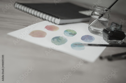Closeup of watercolor or ink painting, minimalistic designer desk 