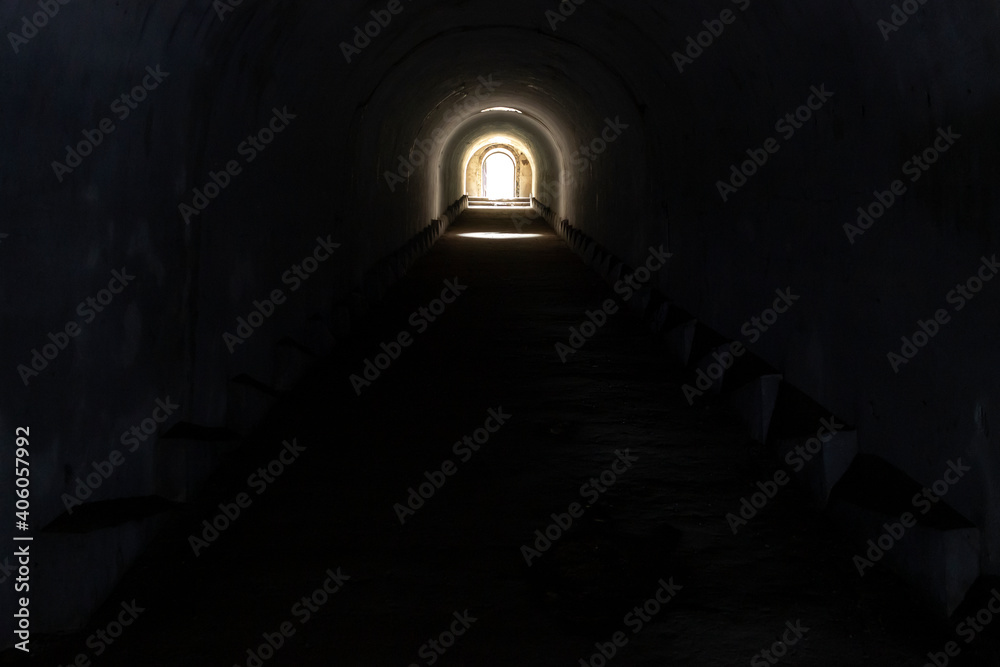 A sunlit exit from a dark dungeon. Light at the end of the tunnel, exit from the underground passage. A sunlit exit from a dark dungeon. Light at the end of the tunnel, exit from the underground passage.