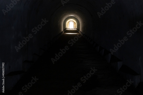 A sunlit exit from a dark dungeon. Light at the end of the tunnel  exit from the underground passage.