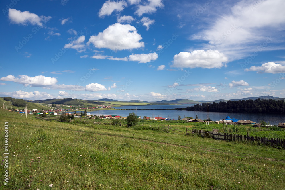 Parnaya village is located on the shore of Lake Bolshoye on a sunny summer day. Krasnoyarsk region. Russia.