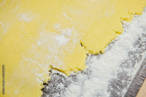 Rolled biscuit dough on a dark kitchen, dough with flour. Robaina club. Place for text photo