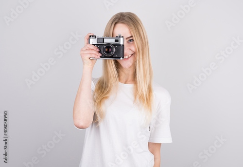Happy smiling young girl holding camera and taking photos © MP Studio
