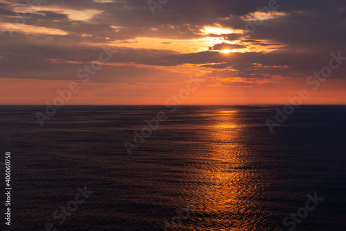 beautiful orange sunset over the dark sea wit an orange line of reflection.