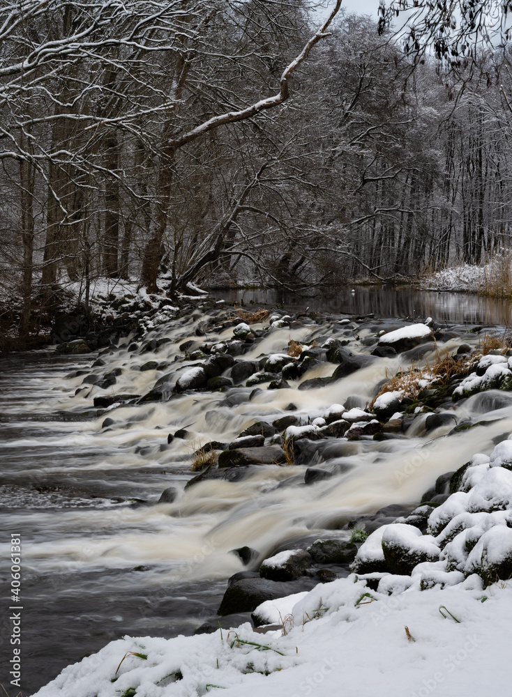 River rapids in a snowy winter forest. Picture Ronne River, Scania county, Sweden River rapids in a snowy winter forest. Picture Ronne River, Scania county, Sweden