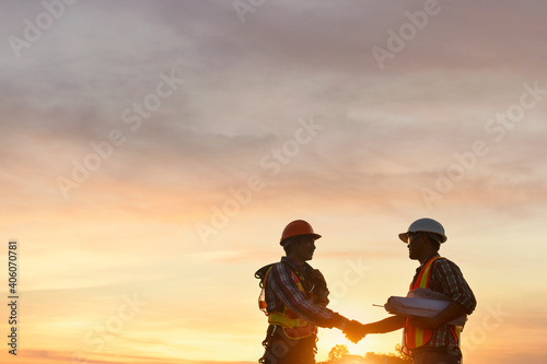 Construction engineers supervising progress of construction Engineering Consulting People on construction site holding blueprint in his hand. Building inspector.