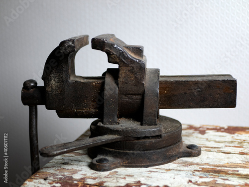 Old rusty vise on a wooden bench. Tool for locksmith. Construction and repair concept