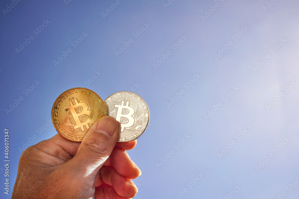Fototapeta premium 青空にかざされたビットコイン