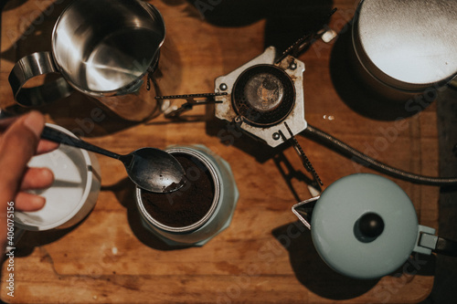 Top view of a man making coffee using mocca pot.Close up shot.Vintage filter effect and artificial grain applied.