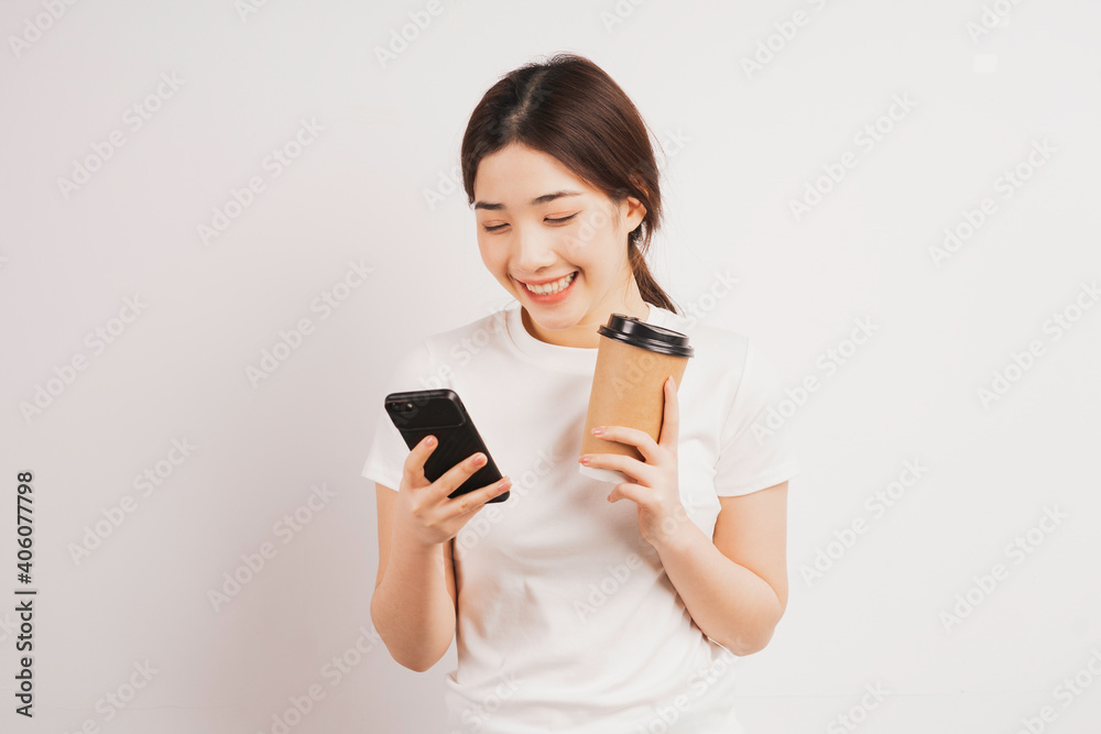 Portrait of young asian girl holding coffee cup and using phone Portrait of young asian girl holding coffee cup and using phone