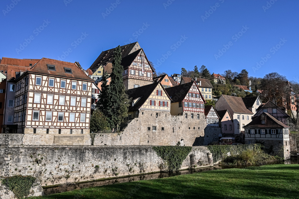 Cityscape of Schwäbisch Hall, Germany with its colorful half-timbered houses and the historic city wall under a clear blue sky.