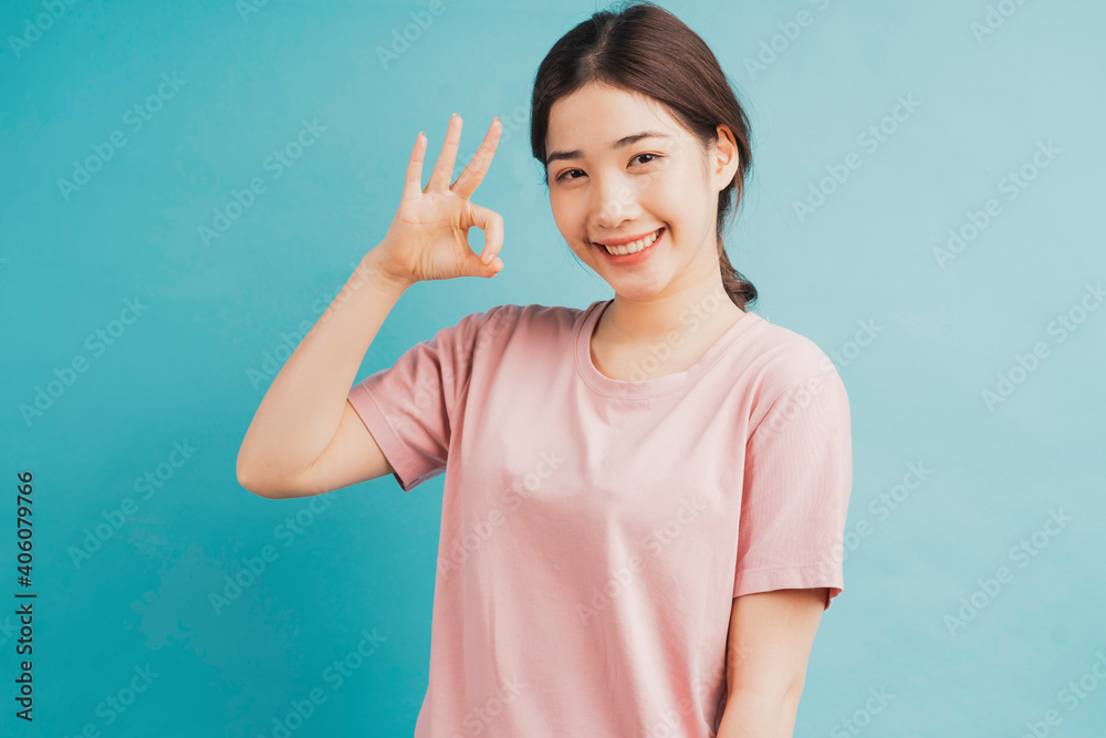 Portrait of girl raising hands of acceptance on blue background Portrait of girl raising hands of acceptance on blue background