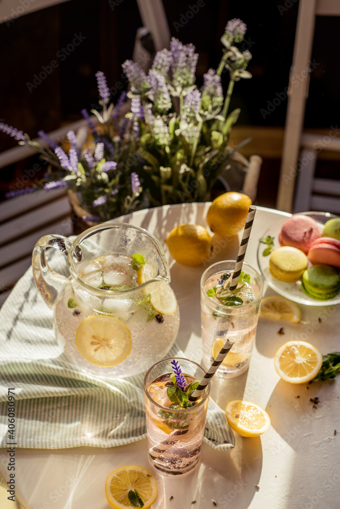 a small table in an outdoor cafe with lemonade, pasta and lavender