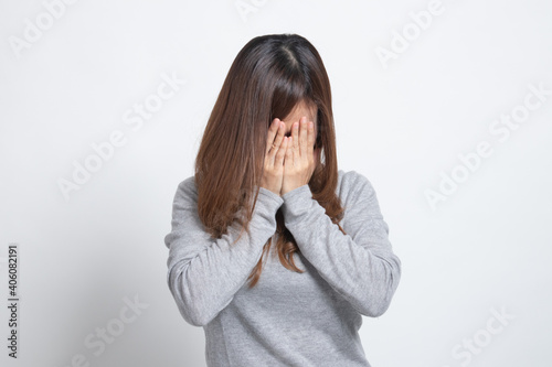 Sad young Asian woman cry with palm to face.