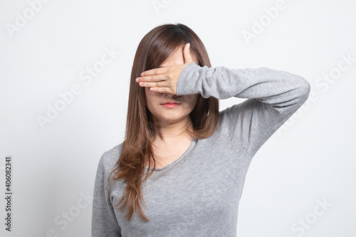 Young Asian woman close her eyes with hand.